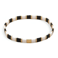 Bracelet fin en perles japonaises noires, blanches et dorées au design rectangulaire élégant.