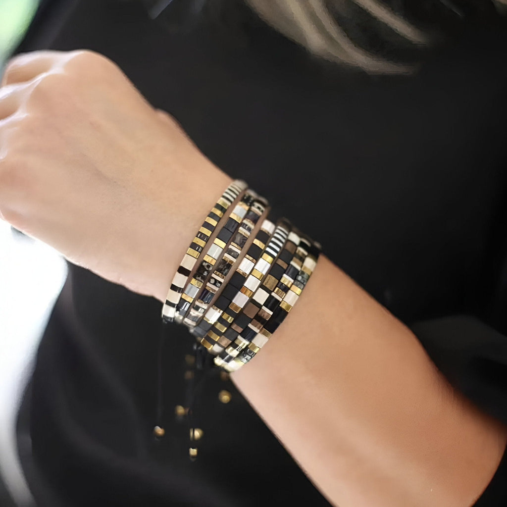 Bracelet femme multi-rangs en perles japonaises noires, blanches et dorées, style élégant et moderne.