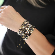 Bracelet femme multi-rangs en perles japonaises noires, blanches et dorées, style élégant et moderne.