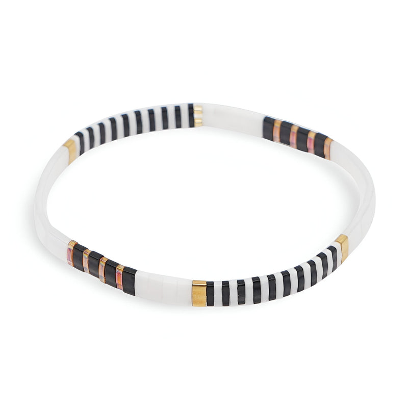 Bracelet femme rigide perles blanches avec motifs rayés noirs, dorés et saumon.