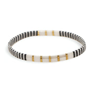 Bracelet en perles fines blanches et noires avec motifs dorés élégants et délicats.