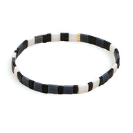 Bracelet fin en perles carrées noires, blanches et une perle dorée élégante.