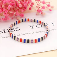 Bracelet femme en perles japonaises multicolores bleu, rouge, noir, blanc, et beige, motif rayé.