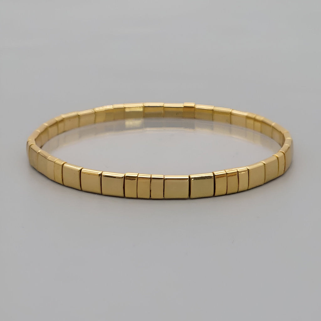 Bracelet doré en perles carrées japonaises, design minimaliste et élégant pour femme.