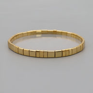 Bracelet doré en perles carrées japonaises, design minimaliste et élégant pour femme.