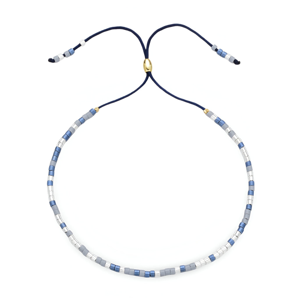 Bracelet Tsunada en perles japonaises bleu clair, blanc et or, cordon réglable bleu marine.