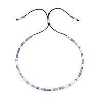 Bracelet Tsunada en perles japonaises bleu clair, blanc et or, cordon réglable bleu marine.