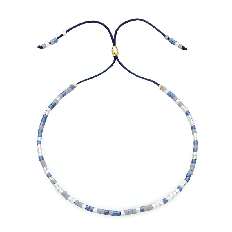 Bracelet Tsunada en perles japonaises bleu clair, blanc et or, cordon réglable bleu marine.