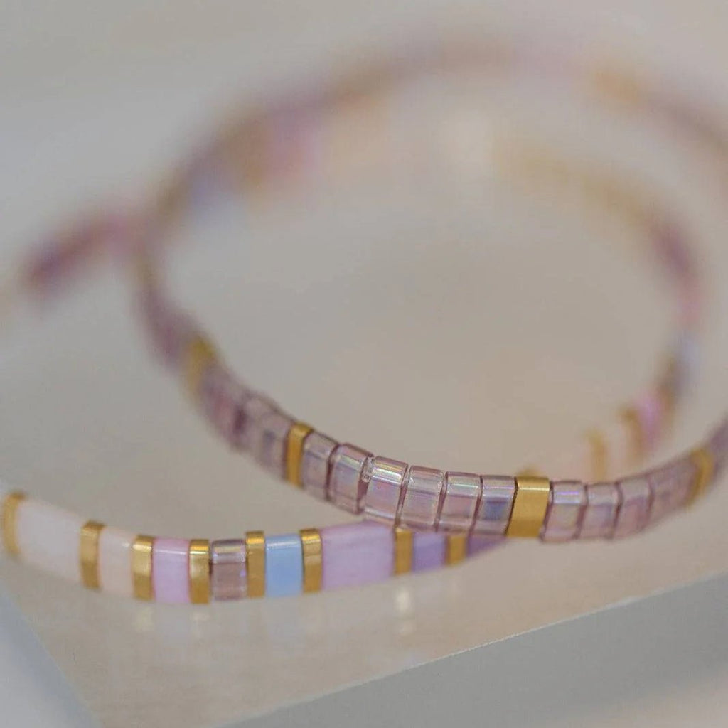 Bracelet pour femme en petites perles carrées roses et mauves avec accents dorés modèle Yamuza.