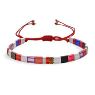 Bracelet femme en perles carrées multicolores sur cordon rouge ajustable.
