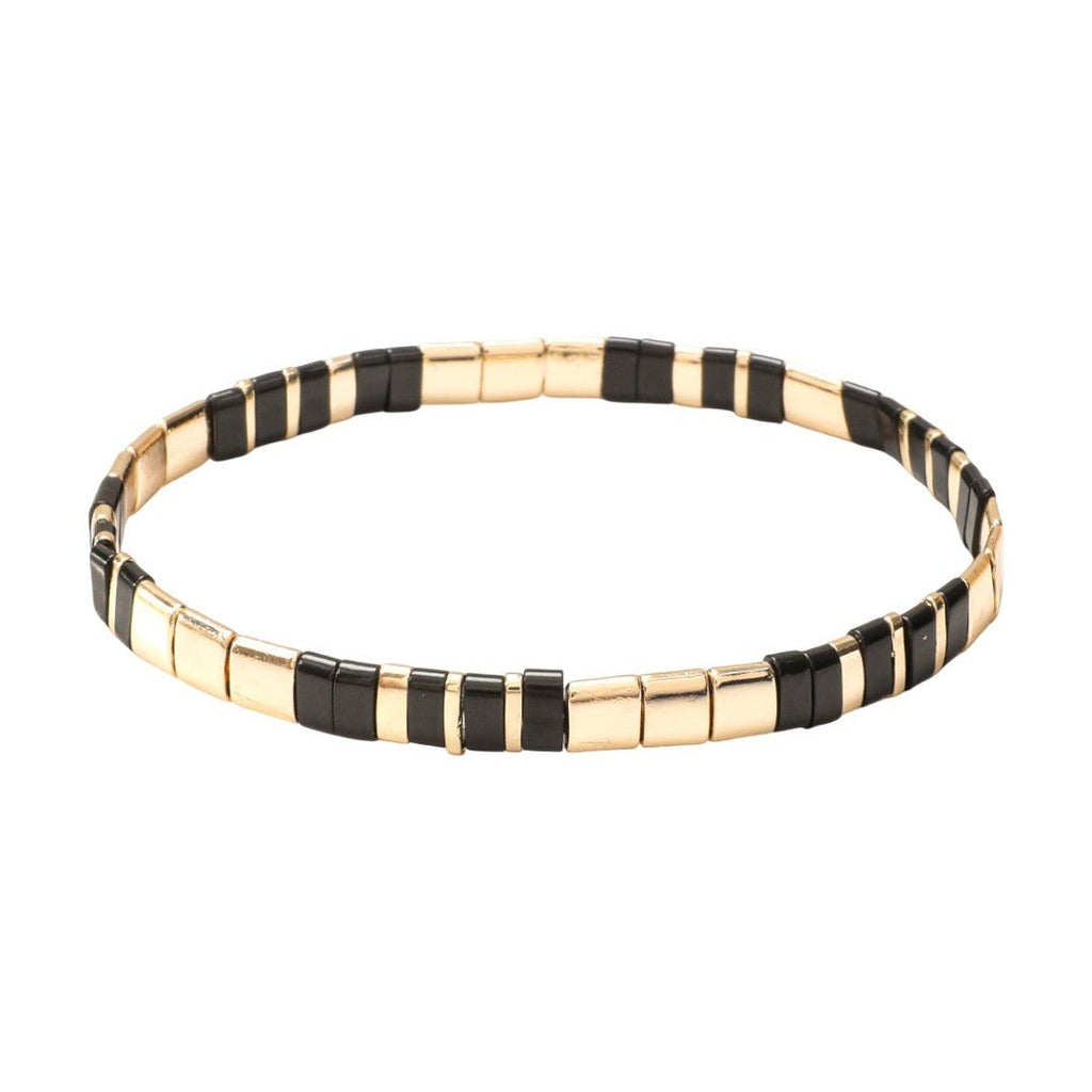 Bracelet souple à enfiler en perles tubulaires dorées et noires alternées, design minimaliste et élégant.