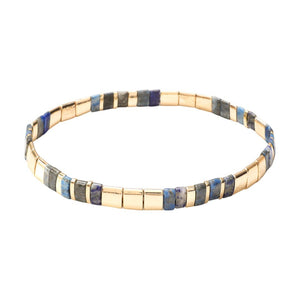 Bracelet souple à enfiler avec perles rectangulaires dorées et multicolores bleu-gris en alternance.