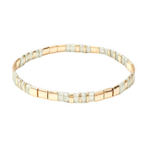 Bracelet souple à enfiler en perles japonaises blanches et dorées, style raffiné et lumineux.