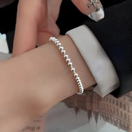 Bracelet femme en perles d'argent sterling lisse, style élégant et minimaliste.