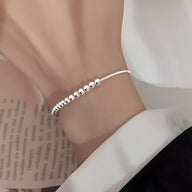 Bracelet fin en argent sterling avec perles brillantes sur un fil délicat.