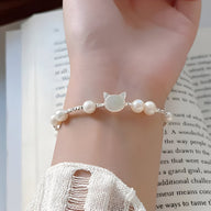Bracelet femme en perles blanches avec pendentif tête de chat en argent sterling.