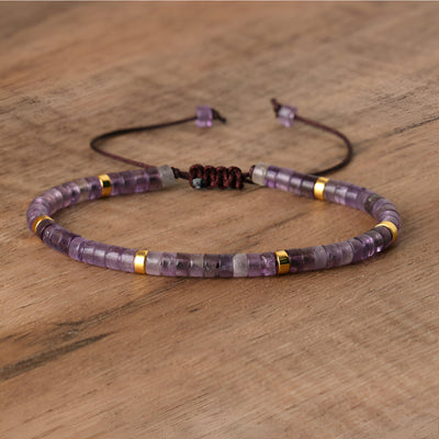 Bracelet mixte en perles heishi améthyste violettes avec détails dorés et fermeture coulissante noire.