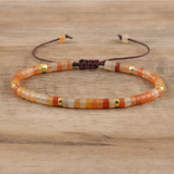 Bracelet mixte en perles heishi orangées en aventurine avec détails en or et cordon ajustable marron.