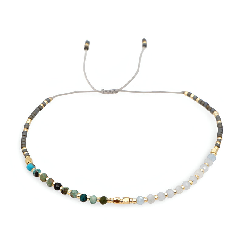 Bracelet femme perles heishi multicolores avec détails en cristal et fermoir coulissant gris.