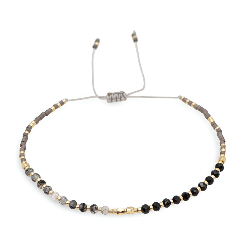 Bracelet réglable perles heishi noires et grises avec petits cristaux dorés et argentés.