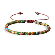 Bracelet réglable en perles heishi jaspe impérial multicolore sur cordon rouge foncé.