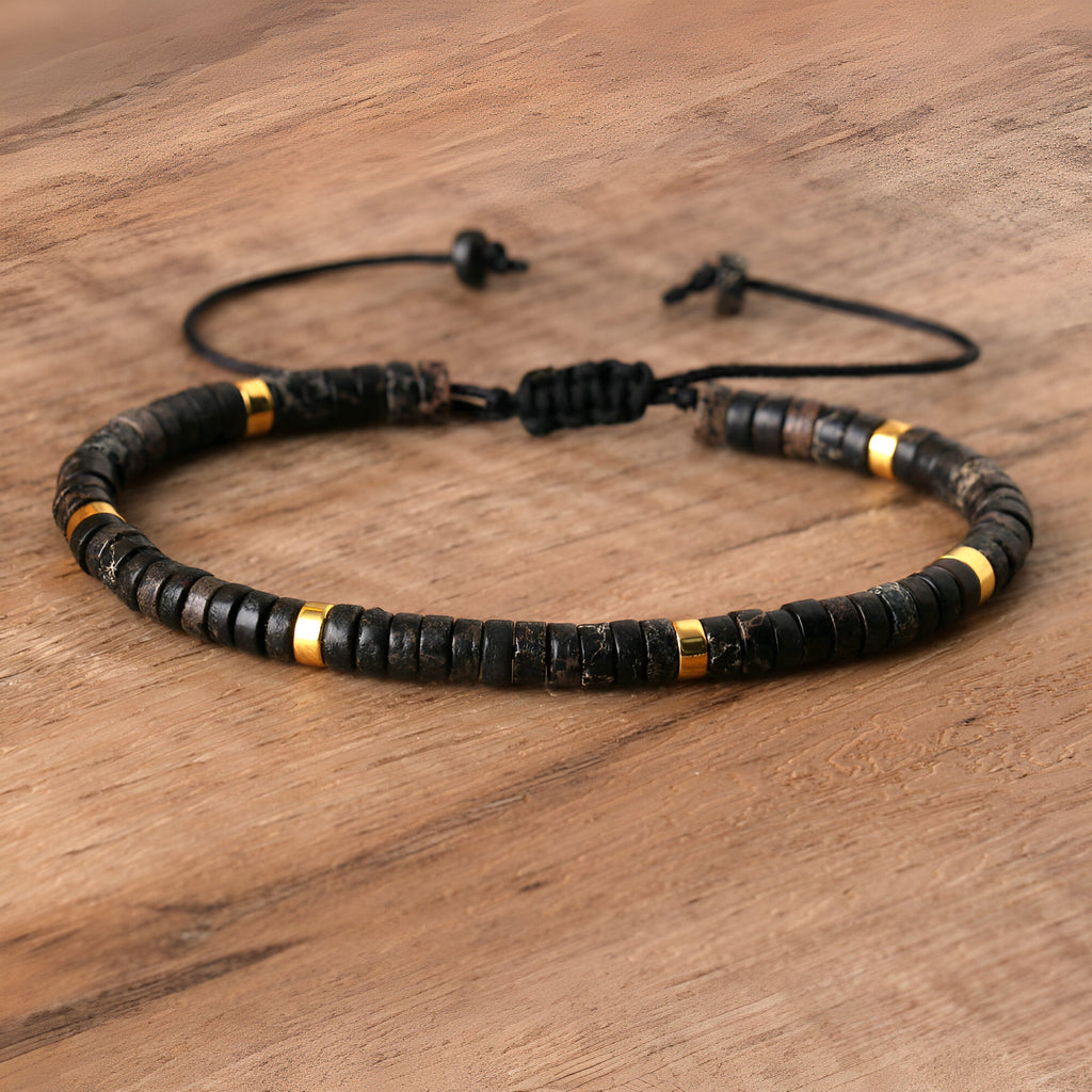 Bracelet mixte perles heishi noires en jaspe impérial avec accents dorés et fermeture coulissante noire.