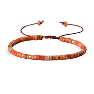 Bracelet mixte en perles heishi jaspe impérial orange avec cordon ajustable marron.