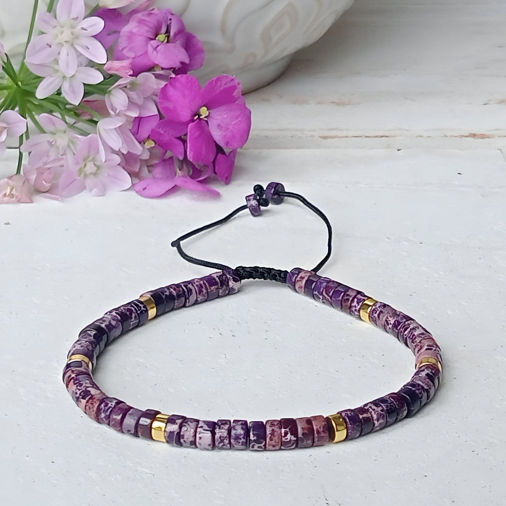 Bracelet mixte en perles heishi jaspe impérial violet avec petits anneaux dorés sur cordon réglable noir.