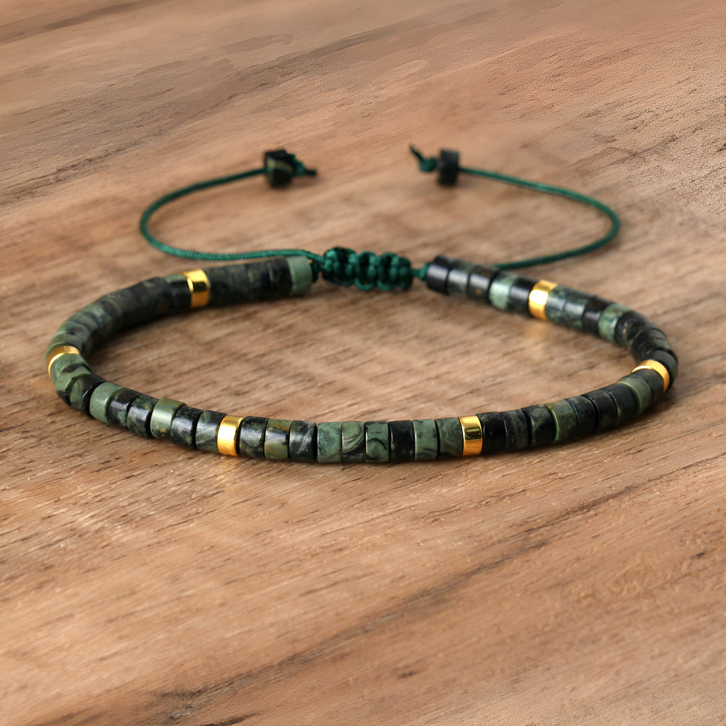 Bracelet mixte en perles heishi vertes de jaspe kambaba avec détails dorés et fermoir coulissant.