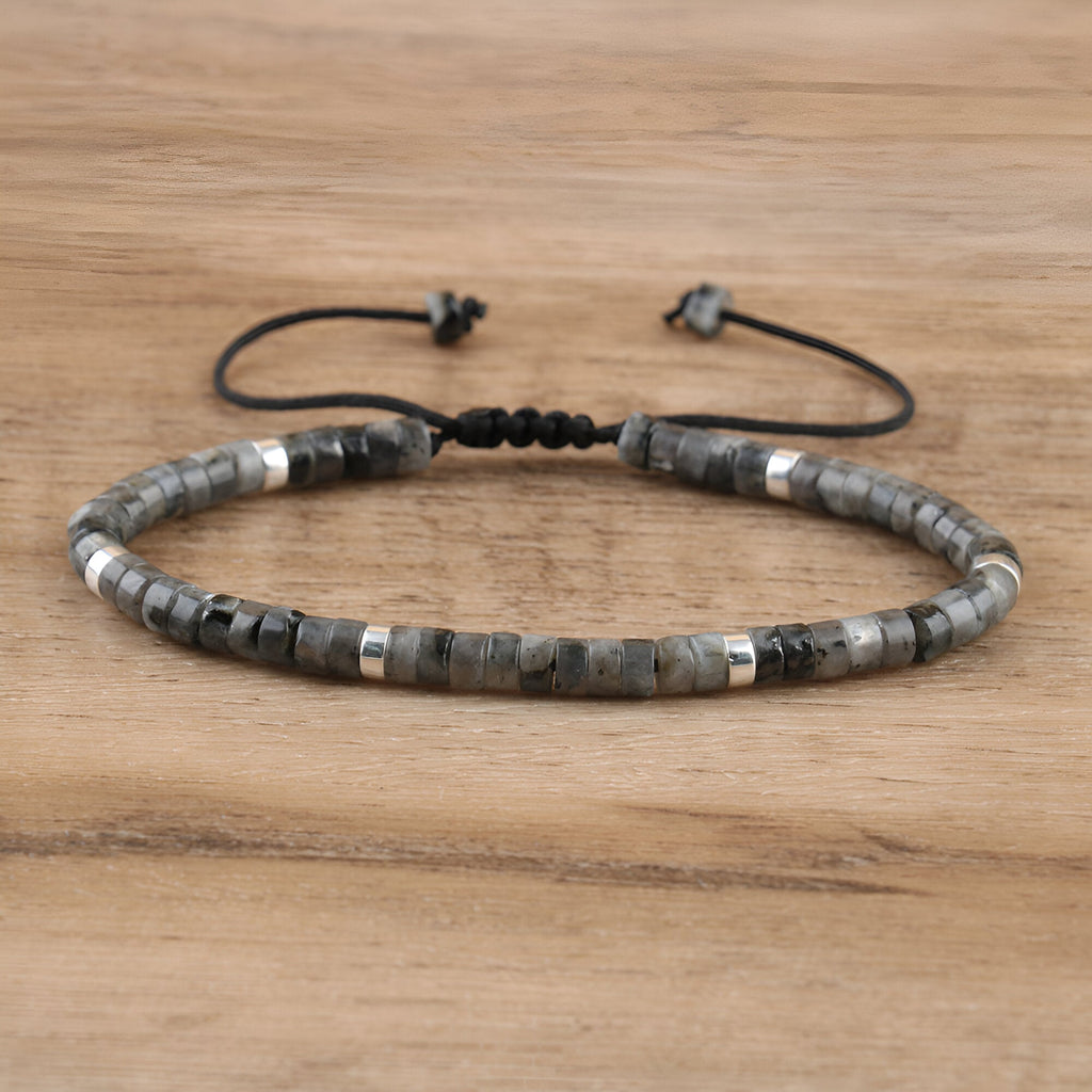Bracelet mixte en perles heishi labradorite noire avec détails métalliques argentés sur cordon réglable noir.