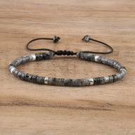 Bracelet mixte en perles heishi labradorite noire avec détails métalliques argentés sur cordon réglable noir.