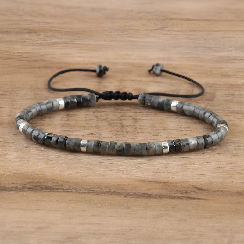 Bracelet mixte en perles heishi labradorite noire avec détails métalliques argentés sur cordon réglable noir.