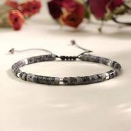 Bracelet mixte en perles heishi noire et labradorite, cordon réglable avec détails métalliques argentés.