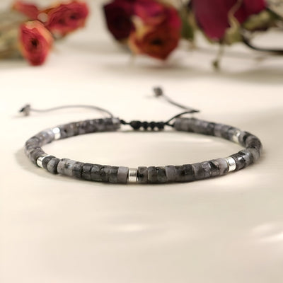 Bracelet mixte en perles heishi noire et labradorite, cordon réglable avec détails métalliques argentés.