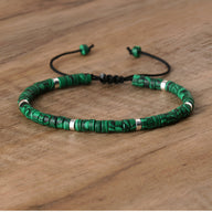 Bracelet mixte en perles heishi vertes malachite avec détails argentés et cordon ajustable noir.