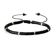Bracelet mixte en perles heishi noires avec intercalaires en onyx et fermeture coulissante noire.
