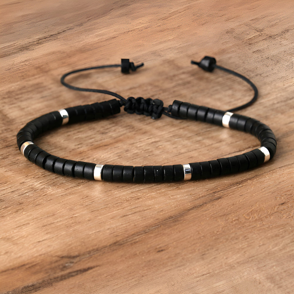 Bracelet mixte réglable en perles heishi noires et onyx avec petits anneaux argentés sur cordon noir.
