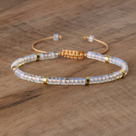 Bracelet mixte en perles heishi blanches et opales, détails dorés, fermoir ajouré en métal rose gold.