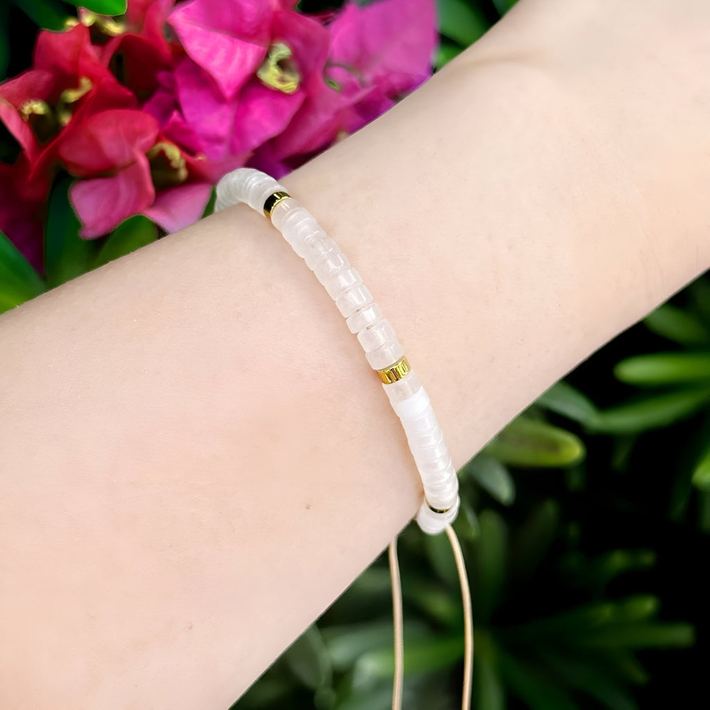 Bracelet mixte en perles heishi blanches et quartz blanc avec détails dorés ajustable.