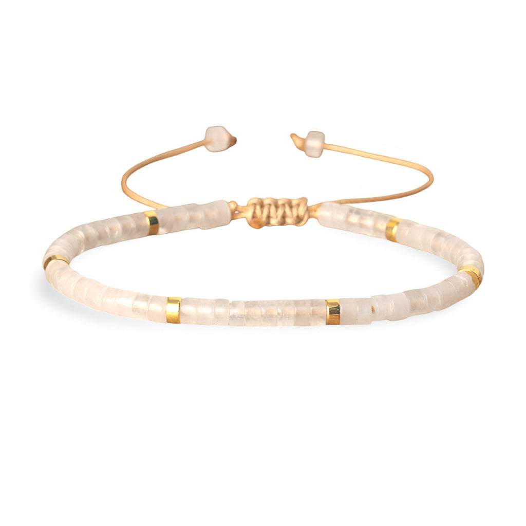 Bracelet mixte en perles heishi blanches avec détails dorés et fermoir coulissant doré.