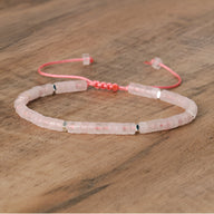 Bracelet mixte en perles heishi quartz rose avec cordon ajustable corail sur bois.