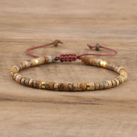 Bracelet mixte en perles heishi marron jaspe et détails dorés avec cordon ajustable rouge.