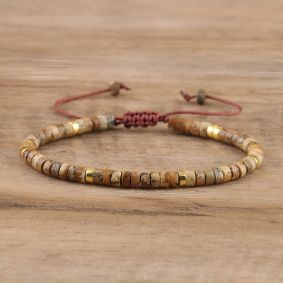 Bracelet mixte en perles heishi marron jaspe et détails dorés avec cordon ajustable rouge.