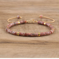 Bracelet mixte en perles heishi rose rhodonite avec éléments dorés et cordon ajustable beige.