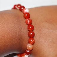 Bracelet mixte en perles d'agate rouges et blanches, finition brillante et lisse.