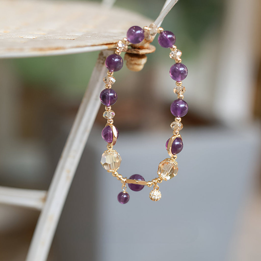 Bracelet femme en pierres d'améthyste violettes montées sur chaîne dorée délicate avec pendentif cercle aplati.
