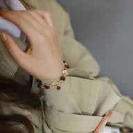 Bracelet femme en perles d'améthyste violettes et billes dorées, style élégant et raffiné.
