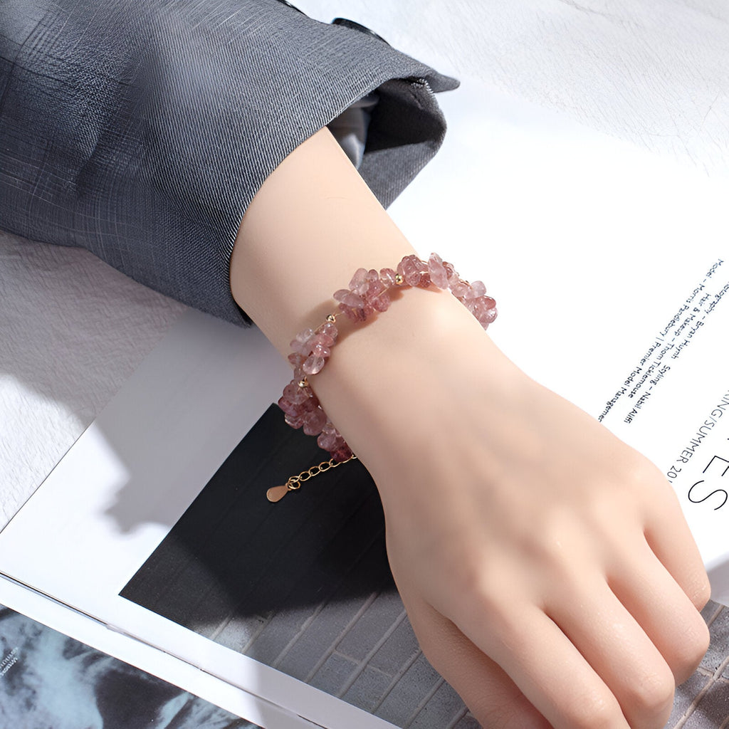 Bracelet femme en pierres de cristal rose clair, design naturel avec fermoir doré ajustable.