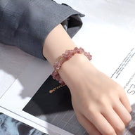 Bracelet femme en pierres de cristal rose clair, design naturel avec fermoir doré ajustable.