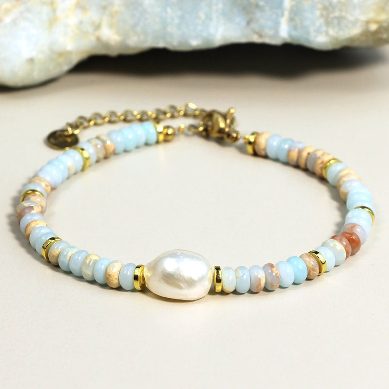 Bracelet multicolore en petites perles rondes avec perle centrale nacrée et fermoir doré.